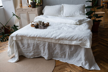 wooden tray with light breakfast on bed on bed with white linen