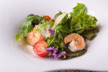 Salad with herbs, shrimps and tomatoes. Mediterranean cuisine. Restaurant serving