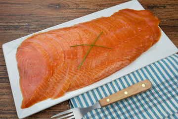 plat de tranches de saumon fumé sur une table	