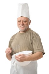 Senior chef whisking egg in kitchen, white background.