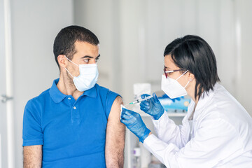 Man receiving covid 19 vaccine jab at vaccination centre