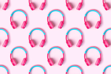Seamless pattern of pink and light blue headphones on pink background. Minimalistic fashion music concept. Top view, flat lay