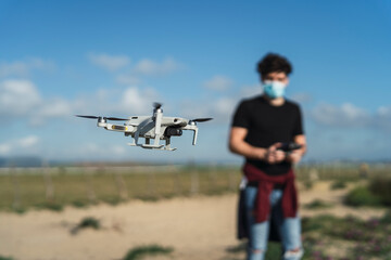 Fototapeta na wymiar Chico apuesto manejando drone en playa de cadiz