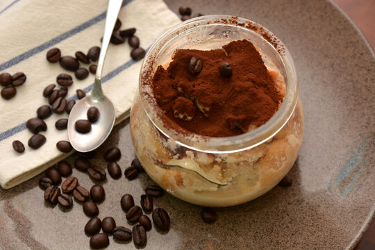 dolce tiramisù in boccale di vetro  tipico dolce italiano con formaggio mascarpone caffè cacao biscotti savoiardi