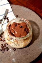 dolce tiramisù in boccale di vetro  tipico dolce italiano con formaggio mascarpone caffè cacao biscotti savoiardi