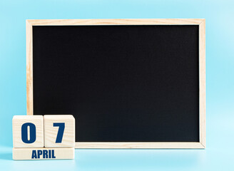 April 7th. Day 7 of month, Cube calendar with date, empty frame on light blue background. Place for your text. Spring month, day of the year concept