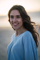 Chica joven en la playa sonriendo siendo feliz y sonriendo