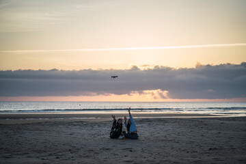 Dos amigas tomando fotos y video con drone en la playa