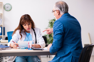 Obraz premium Old businessman visiting young female doctor