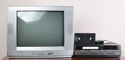 Old silver vintage TV with VCR on wallpaper background.	1980s,1970s.