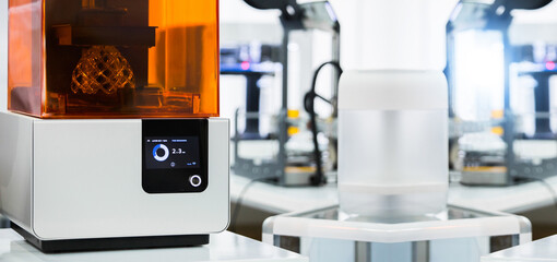 A stereolithography 3d printer in the laboratory prints a structure from a photopolymer.  On the display the process indicator and the number of layers. 
