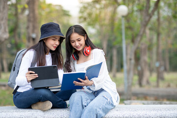 Obraz premium Asian female students walking and talking each other in a campus at sunset with a warm light,Education concept, 