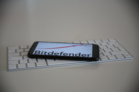Leipzig, Germany - April 11, 2021: Closeup of smartphone screen with logo lettering of Bitdefender on computer keyboard (focus on center upper lettering)