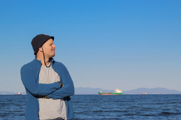 A man in a hat against the backdrop of a seascape.
