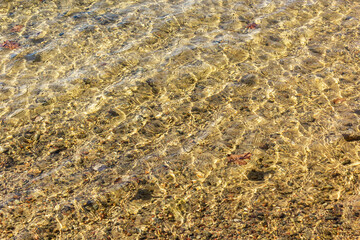 Transparent sea and crystal clear golden water in early spring. Beautiful background