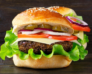 Cheeseburger on a wooden background. Hamburger with cheese. Burger isolated. Tasty dinner. Copy space