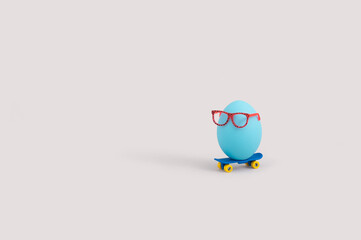 Creative food concept with blue egg wearing eyeglasses and riding skateboard