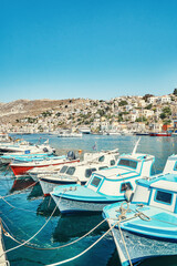 Obraz premium Moored motorboats on azure sea with reflection against city