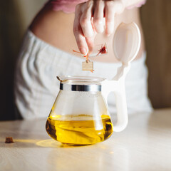 girl brews saffron in a transparent teapot