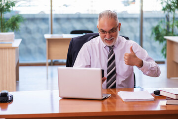 Old businessman employee working in the office