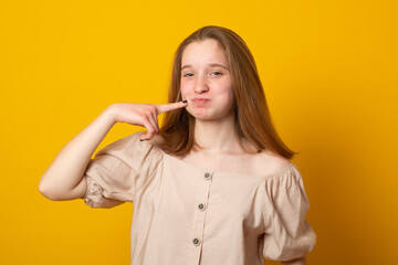 Young girl in summer dress shows Italian sign tasty, pressing a finger to the cheek. Language of...