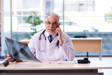 Old male doctor radiologist working in the clinic