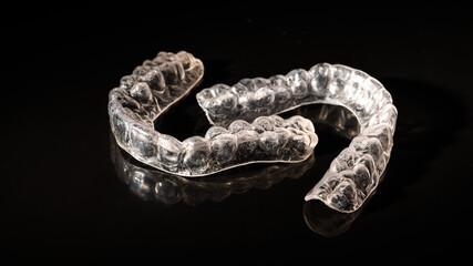 Removable plastic retainers for bite correction on a black background