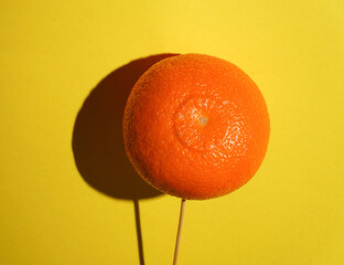 Ripe juicy orange mandarine tangerine as fruit Candy lollipop on bright yellow background with deep...