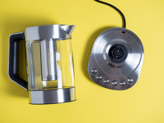 electric metal kettle in silver color with different modes of water heating on a bright yellow background. Top view, flat lay