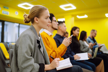 Group of people take notes,  listening to a lecturer or speaker at a conference. Business group meeting seminar training concept. Planning, analysis, collaborate work in teamwork.