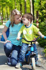 Happy family concept. Mother and son are playing in the playground and laughing on a summer walk on a sunny day.  Family holiday and togetherness, selective focus