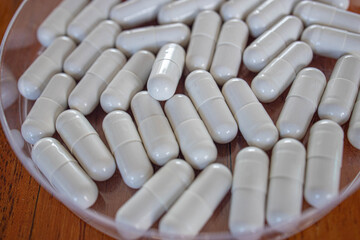 Drug pills in various shape and sizes on wooded table, space for text