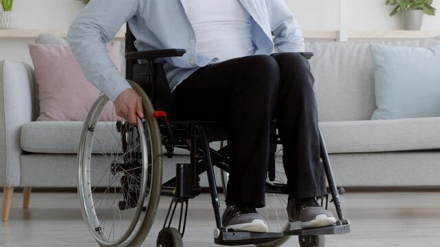 Unrecognizable Handicapped Man In Wheelchair Riding Invalid Carriage At Home