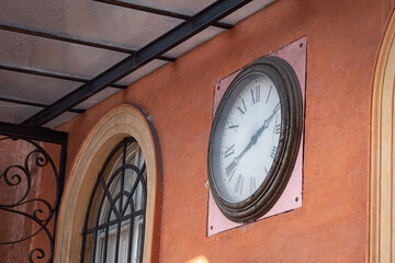 Fototapeta na wymiar Antique Clock with Roman Numerals Placed on the Wall of the Local Public Transport Bus Headquarters, Parma - Italy