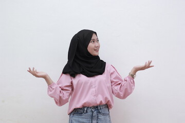Portrait of young muslim girl in hijab felt confused in making two choices. over white background. Beautiful asian woman with casual dress. Beautiful muslim women.