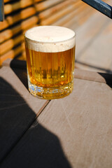 A glass of beer stands on the wooden floor of the pub