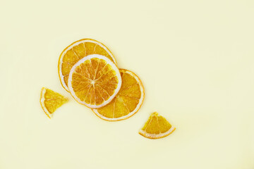 Dried orange slices, chips on yellow background. Dehydrated crispy fruit slices. Healthy organic snack. Close up, top view