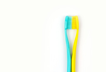 Blue and yellow toothbrushes on a white isolated background.