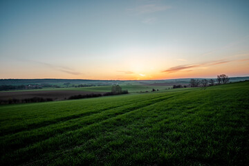 Sunrise over green grassy fields in the "Elm"