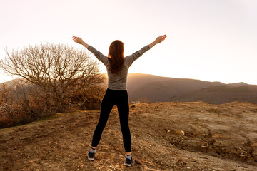Woman looking on sunrize in the mountains