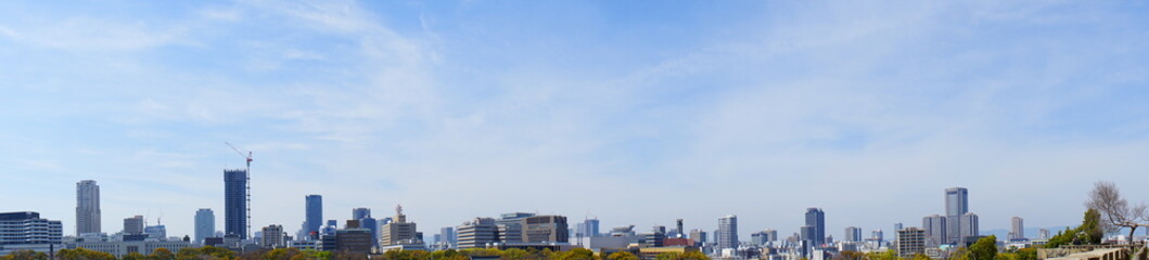 Fototapeta na wymiar City landscape of Osaka, Japan from Osaka castle park. Panoramic view during spring. - 大阪の都市景観 大阪城公園から