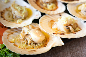 Seafood platter of large piece Scallops grilled with garlic and butter, special delicious menu. Close-up and selective focus at once piece of the scallop.