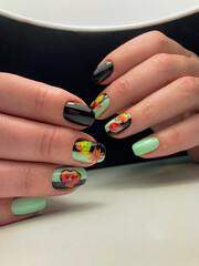 The work of a manicure master. Hands of a beautiful young woman and modern design.