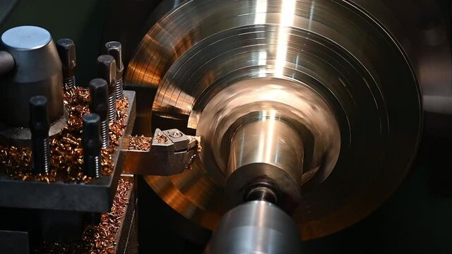 Slow motion  operation of lathe machine cutting the brass shaft material. The metalworking process by turning machine.