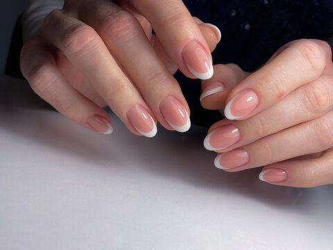 The work of a manicure master. Hands of a beautiful young woman and modern design.