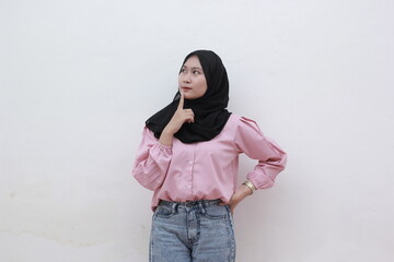 Young Muslim women put their clothes on their chins and feel confused in their choices. Beautiful asian woman with casual dress. Beautiful muslim women.