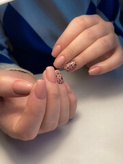 The work of a manicure master. Hands of a beautiful young woman and modern design.