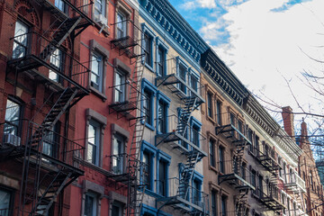 Fototapeta na wymiar Row of Colorful Old Brick Apartment Buildings in Greenwich Village of New York City with Fire Escapes