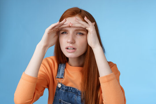 Worried Clingy Redhead Girlfriend Spying Boyfriend Peer From Distance Squinting Focus Sight Look Afar Hold Hands Forehead Cover Eyes Sunlight Standing Concentrated Blue Background