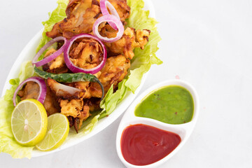 Onion Pakoda Also Known As Kanda Bhajji, Pyaj Ke Pakode, Pakoda, Pyaaj Pakore, Pakora, Pyaaz Bajji Is Enjoyed In Rainy Season Across North And South India. Served With Green Chutney And Ketchup Sauce